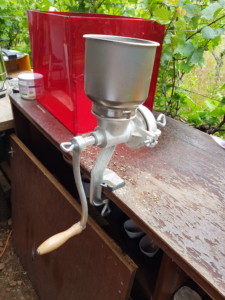 Moulin à céréales fixé sur un rebord de table, prêt à moudre le houblon pour préparer la bière.