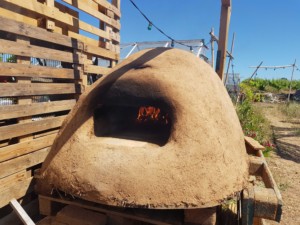 Le four terre-paille vu de face, un feu rougeoyant en son sein