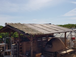 Toit au dessus du four en terre-paille partiellement recouvert de bambous alignés.