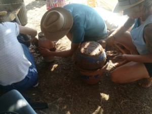 Trois personnes en train d'assembler des pots en céramique à l'aide de glaise pour créer des Oyas